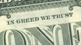 Primer plano de billete de un dolar con la leyenda "in greed we trust"