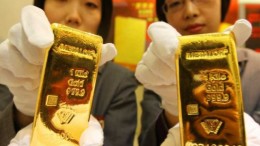 Dos mujeres chinas con lingotes de oro en las manos