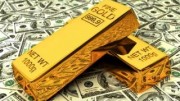 Lingotes de oro encima de billetes de dólares