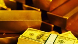 Lingotes de oro y fajo de billetes de dolar